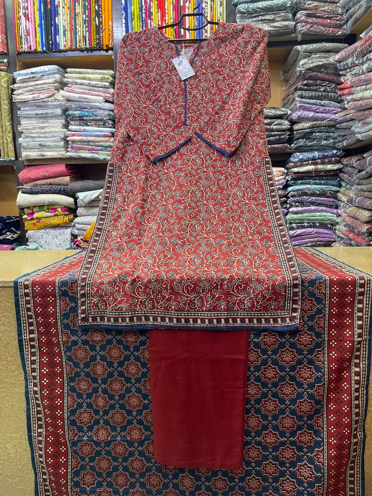 Bin Saeed Printed Khaddar 3-Piece Suit with Printed Shawl – Rust Red & Indigo Ajrak Style Design